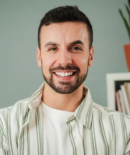 Smiling male dentist wearing a striped shirt at Beverly Hills dental practice.