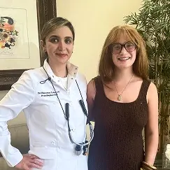 Female dentist and patient smiling together at Beverly Hills dental practice.